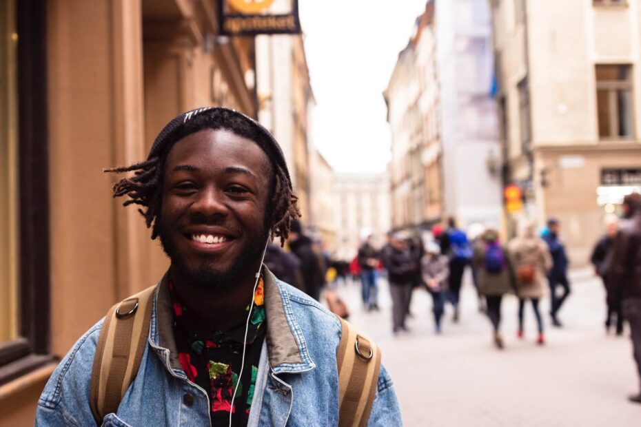 care-leaver-housing-young-adult-smiling-walking-while-holding-a-rucksack