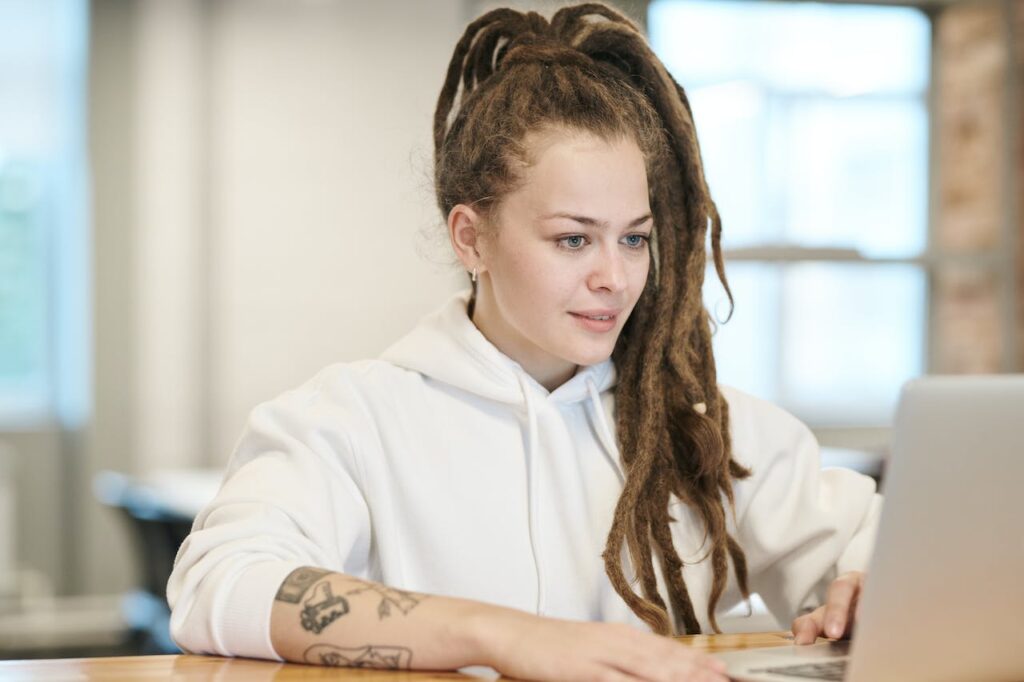 supported-accommodation-london-young-woman-smiling-on-her-laptop